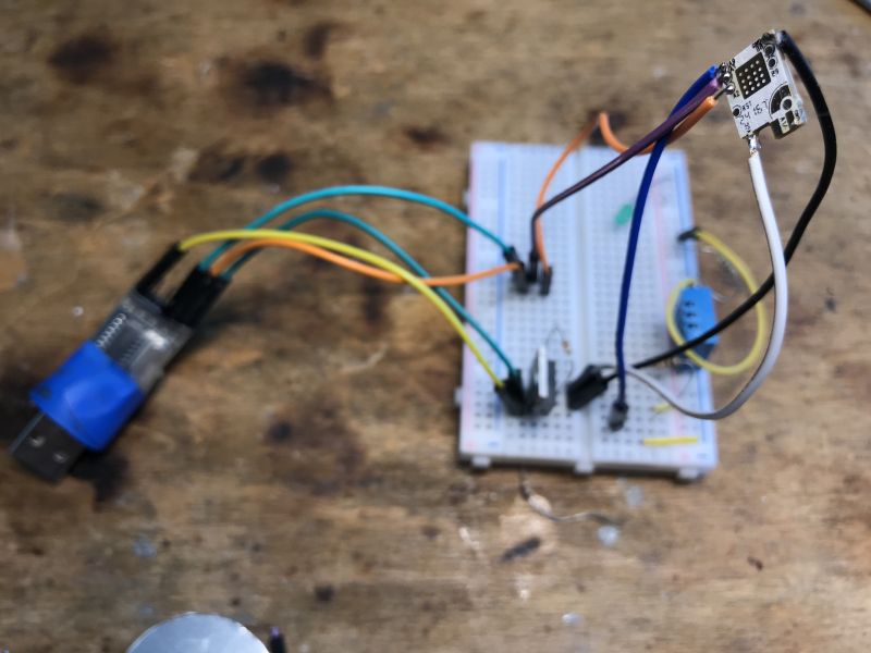 Flashing a Wi-Fi Module from an LED Lamp on a Breadboard USB-UART adapter connected to a breadboard with wires leading to a Wi-Fi module removed from an LED lamp.