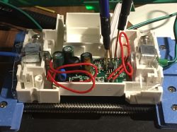 Close-up of an open electronic device with connected wires and test probes.
