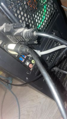 Zbliżenie na tylny panel komputera z podłączonymi kablami HDMI i USB.