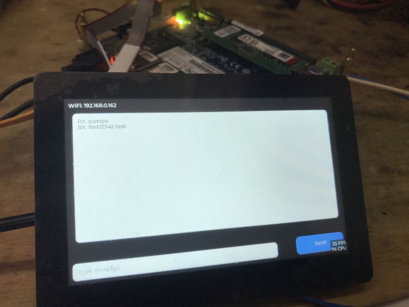 Tablet z aplikacją czatu; widoczny adres Wi‑Fi 192.168.0.162 i krótkie wiadomości.