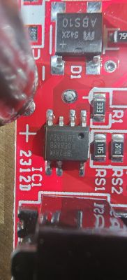 Zbliżenie czerwonej płytki PCB sterownika LED z układem 8-pin i elementami SMD, widoczny symbol plusa