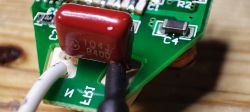 Close-up of the internal circuit of a light bulb with a visible red capacitor.