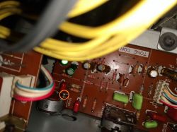 Zbliżenie na płytkę drukowaną z komponentami elektronicznymi i kablami.