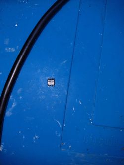 Small 8-pin KM311S08N chip on a blue anti-static work mat