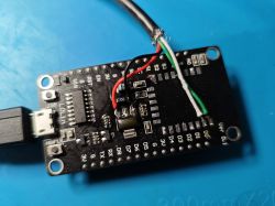 NodeMCU/ESP8266 board with USB cable wires soldered to it; visible wires are red, black, white, and green.