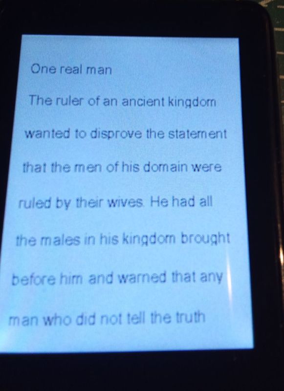 Ekran urządzenia z angielskim tekstem; nagłówek „One real man” i fragment opowiadania.