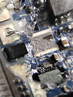 Close-up of a damaged circuit board with visible signs of burning.
