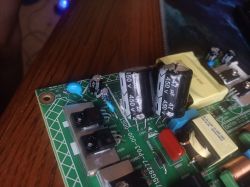 Zbliżenie na płytkę drukowaną z kilkoma kondensatorami i elementami elektronicznymi.