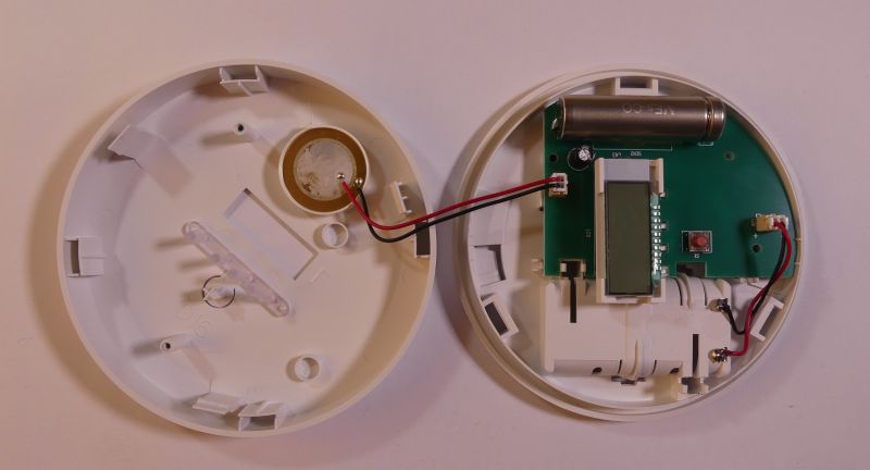 Wnętrze otwartego czujnika dymu z elektroniką i baterią