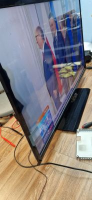 Telewizor Toshiba 40RL939 na biurku pokazujący program telewizyjny.