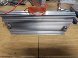 Radiator aluminiowy z przymocowaną matą grzewczą i czerwonymi przewodami