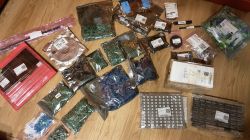 Zestaw zapakowanych elementów elektronicznych ułożonych na podłodze drewnianej