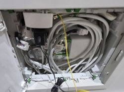 Wnętrze skrzynki telekomunikacyjnej z kablami światłowodowymi i ethernetowymi
