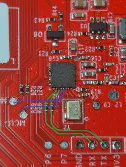 Image of a section of a red printed circuit board with visible traces and electronic components. Green and blue lines indicate UART1 and UART2 connections.