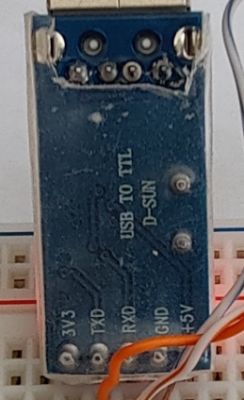 USB to TTL adapter on a breadboard with wire connections.
