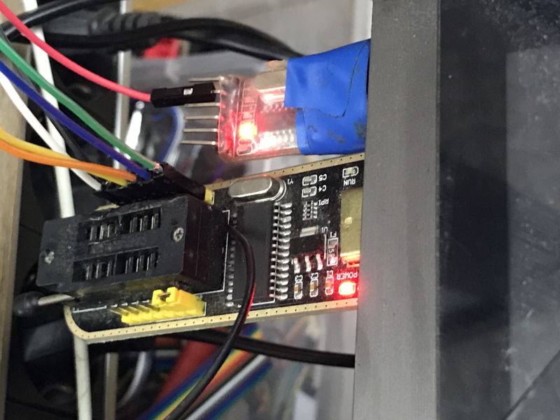 EEPROM programmer with connected wires and illuminated LEDs