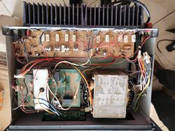 Widok wnętrza urządzenia elektronicznego z widocznymi płytkami drukowanymi, dużym transformatorem oraz okablowaniem.