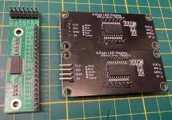 Moduł MCP23017 i dwa wyświetlacze LED na tle siatki.