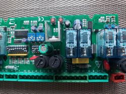 Płytka drukowana z elementami elektronicznymi i przekaźnikami.