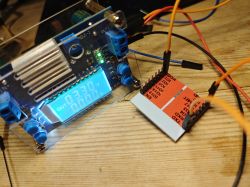 Power supply module and prototyping board on a wooden table.