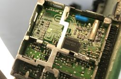 Zbliżenie na zieloną płytkę PCB w metalowej obudowie z układem IX2360VA i złączem pinowym
