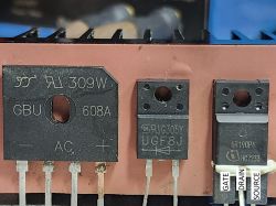 Three electronic components: bridge rectifier and transistors Close-up of three electronic components mounted on a copper heatsink