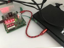 UPS connected to a meter; red LED displays show 6.834 and 2.51, with cables on a desk