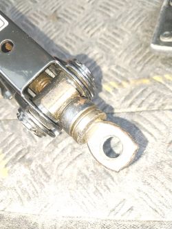 Zbliżenie na mechanizm metalowego podnośnika samochodowego na wzorzystej powierzchni.