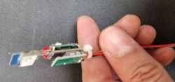 Image of an electronic module held in fingers, including additional boards.