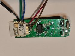 Close-up of an electronic module with several wires attached to a PCB on a white background.
