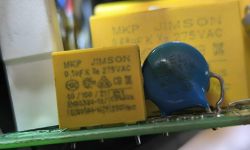 Zbliżenie na kondensator MKP i niebieski warystor 10D431K na płytce elektronicznej.
