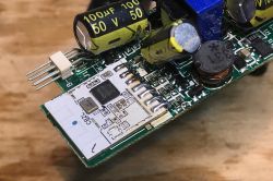 Close-up of a PCB with a CB2L module, capacitors and an inductor; a pin header is visible at the edge.