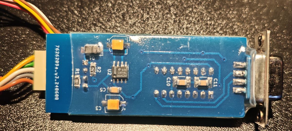 Niebieska płytka PCB z układami SMD i złączem DB9 oraz kolorowymi przewodami
