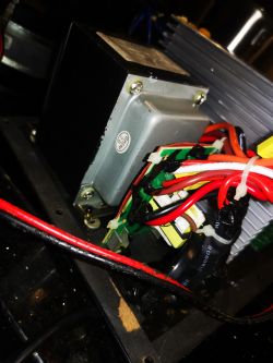 Blok transformatora wewnątrz subwoofera z czarnym nalotem i kablami