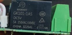 Close-up of MANHOT GK101-1AS relay on a PCB with markings DC5V, 5A 250VAC/30VDC.