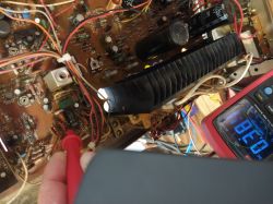 Wnętrze urządzenia z płytką PCB, sondą multimetru i wyświetlaczem pokazującym 6,37 V