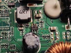 Makrofotografia PCB z cewką „4R7” i nadpalonym układem SMD obok
