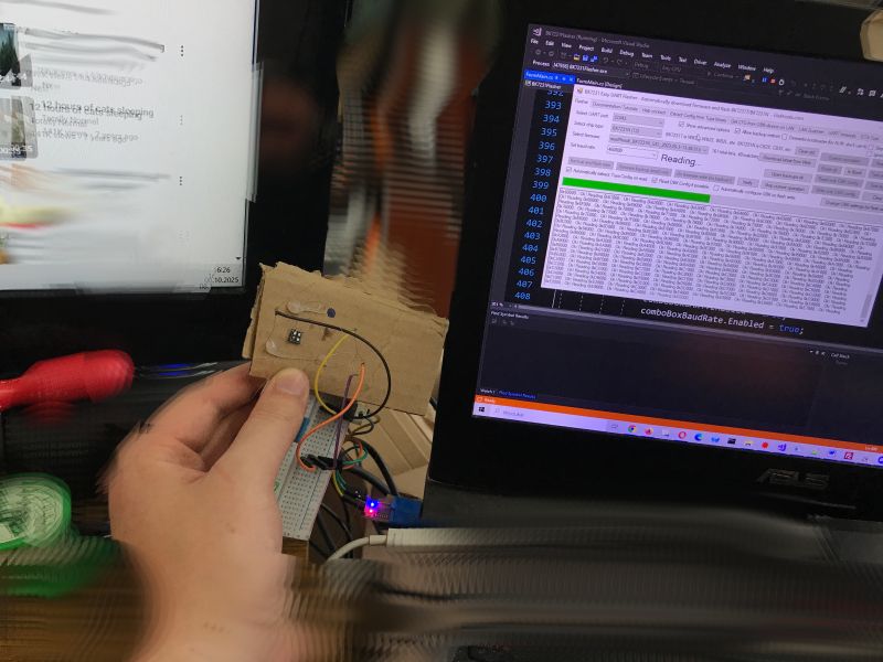 Cardboard sensor prototype connected to a laptop Person holding a cardboard-mounted sensor connected to a breadboard and laptop