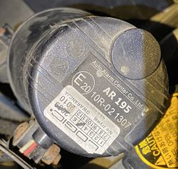 Czarna syrena alarmowa samochodowa Auto Alarm Center Co. Ltd., model AR195, z naklejką gwarancyjną i oznaczeniem homologacji.