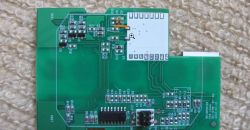 Green circuit board with various electrical components.
