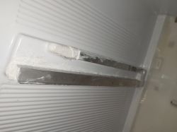Zbliżenie na aluminiowy kątownik w lodówce wklejony na klej.