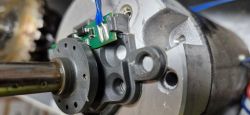 Zbliżenie na enkoder z plastikową flanszą i trzema magnesami.