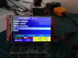 LCD screen showing an MP3 folder list and audio parameters on an electronics workbench