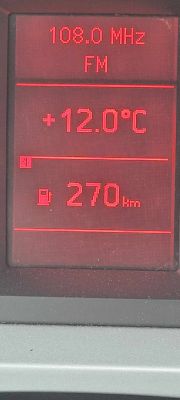 Ekran FIS w Audi A6 C6 pokazujący temperaturę, stację radiową i zasięg.