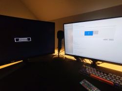 Dwa monitory na biurku; lewy wyświetla komunikat „Display cable not connected”, prawy działa poprawnie z widocznymi ustawieniami ekranu.