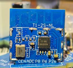 Close-up of blue PCB with T1-2S-NL radio module and surface-mounted ICs