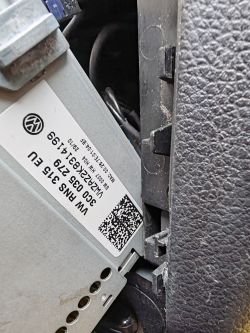 Close-up of a car module with a VW label, part numbers, and a QR code