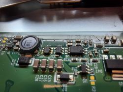 Zbliżenie na płytkę drukowaną z widocznymi elementami elektronicznymi, w tym element oznaczony jako U10 w obudowie SOT-23-5 z kodem SMD A017.