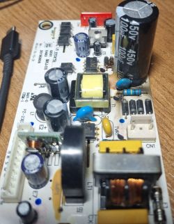 Przepalony obszar na płytce PCB z widocznym uszkodzeniem przy dużym kondensatorze 450V.