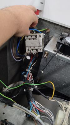 Osoba trzymająca przewody elektryczne w pralnicy Primus FS10.